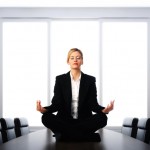 Business woman meditating on desk